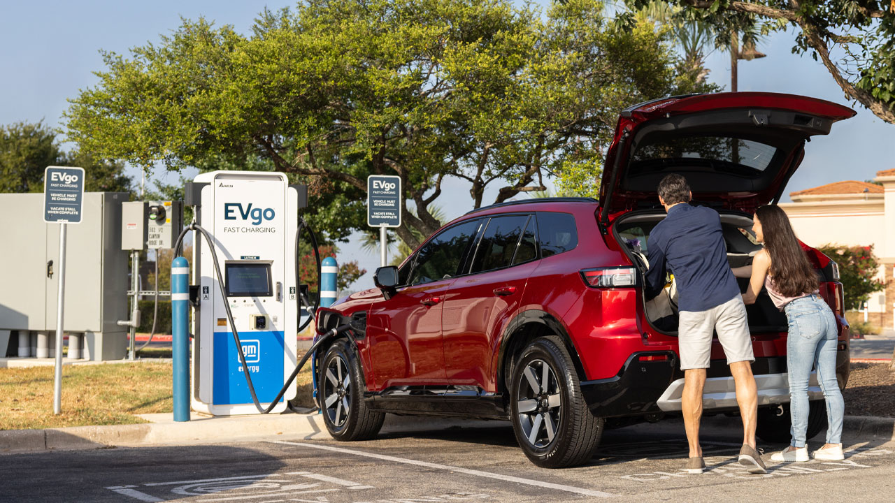 Traveling couple charging at an EVgo fast charging station